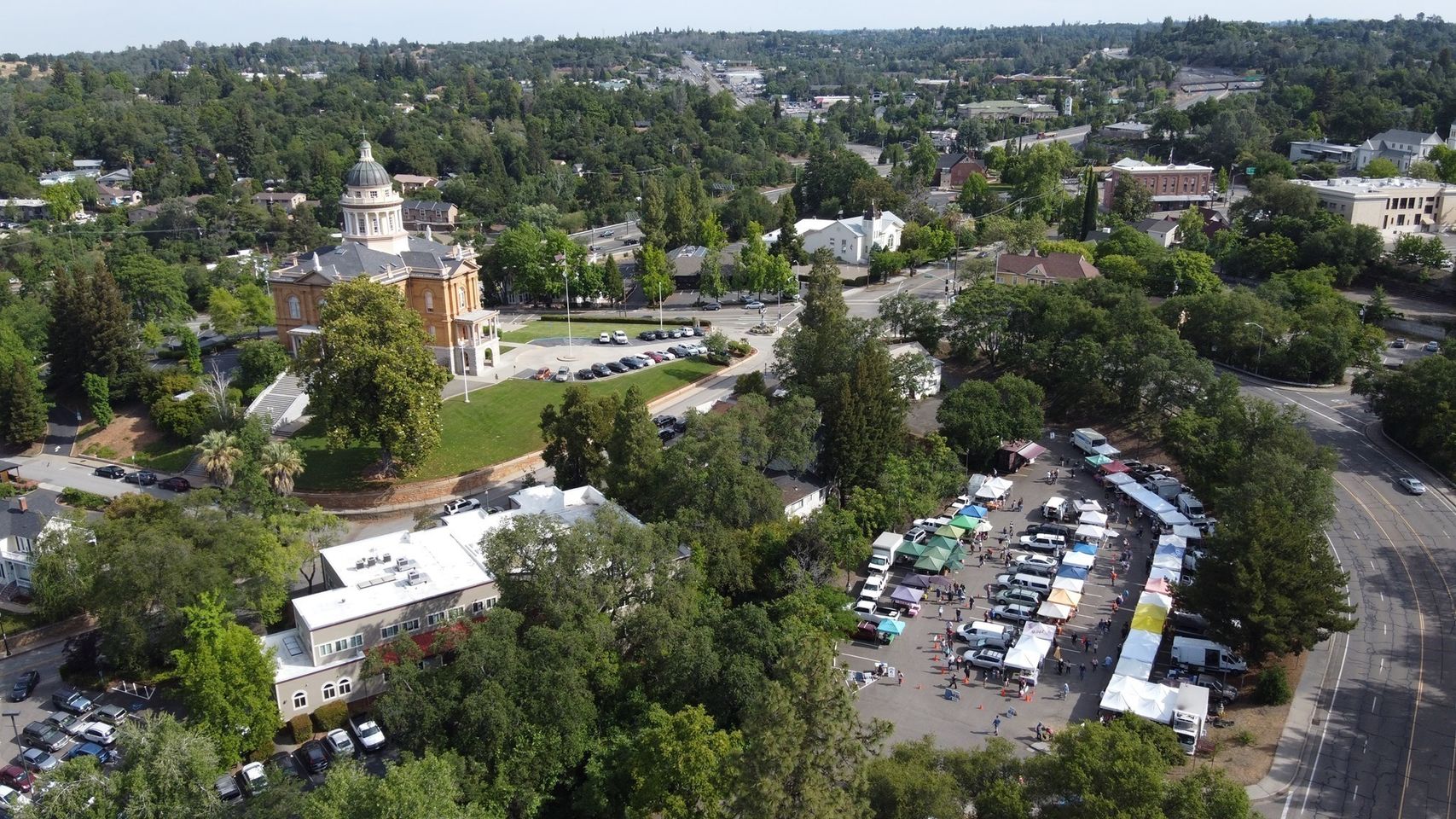 Aerial view of Old Town Auburn — market canopies filling the lot beside the Placer County Courthouse.